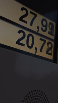Station manager updates live rates as photographer photographs urban consumer pricing tensio