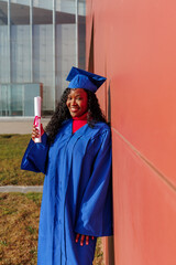 African american woman graduate proudly holding her diploma, smiling for success
