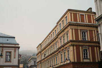 Obraz premium Historic street lined with classical buildings in morning Sarajevo. Repeating facades create rhythm and show everyday urban life and architectural continuity.