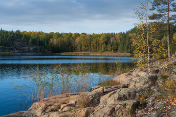 The rocky shore of Lake Ladoga on a small island in the Ladoga Skerries National Park, near the village of Lumivara, on a sunny autumn day, Republic of Karelia, Russia