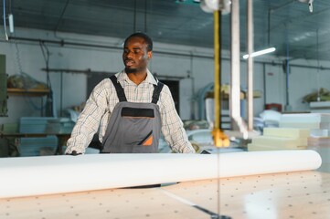 Skilled worker operating cnc machine in furniture factory