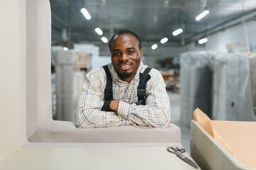 African american craftsman working in modern furniture factory