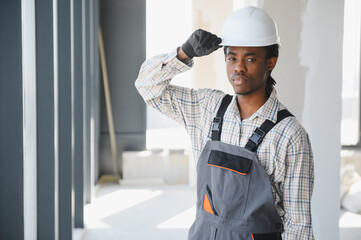 Construction worker adjusting hardhat on building site