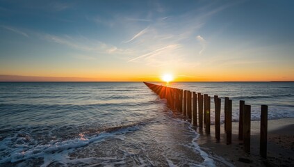 Obraz premium Early daylight illuminating wooden spur dykes along the North Sea coast in Zeeland, erosion control measures