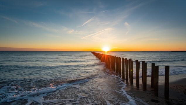 Early daylight illuminating wooden spur dykes along the North Sea coast in Zeeland, erosion control measures
