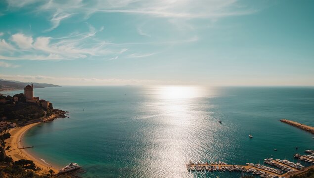 Wide-angle shot of a seaside village with historic buildings, highlighting preservation and seasonal change, Earth Day