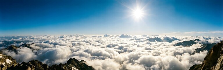 Naklejka premium Panoramic Mountain View Above Clouds with Bright Sun