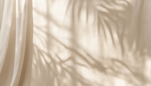 Soft sunlight shadows of tropical palm leaves cast on a neutral curtain creating a minimalist background for design projects