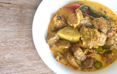 spicy boiled slice beef with lemon leaf in coconut milk green curry soup on bowl
