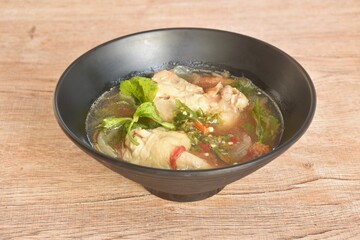 spicy chicken meat with onion and tomato in tom yum soup on bowl