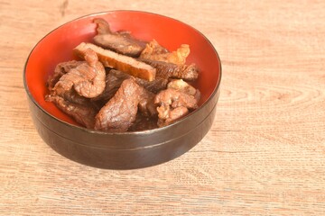 fried crispy salty fermenting beef fat meat with pepper on bowl