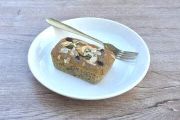 butter banana cake topping peanut and whole grain couple raisin with golden fork on plate