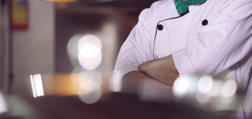 professional chef stands and working in a modern kitchen, wearing a white uniform. This image conveys expertise, focus, and readiness in a high demand culinary environment for restaurant profile