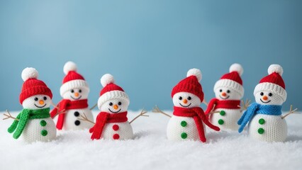Small, knitted snowmen with colorful hats and scarves, arranged on snow