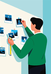 Man meticulously arranges framed landscape photos on a wall with a measuring tape