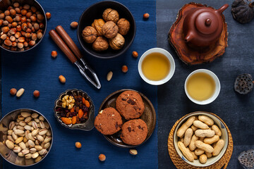Food themed still life with crockery, various nuts and tea. Flat lay. Top view.
