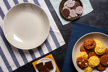 Bowl and Bowl and plates with cookies on black chalkboard texture. Flat lay. Top view. Food concept.with cookies on black chalkboard