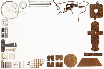 A group of various old and new bits and pieces arranged on white. Old rusty nuts, bolts, nails and other parts flay lay on white background.