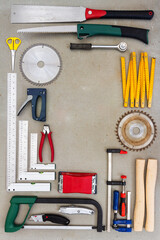 Flat lay of old hand tools on concrete background. Large collection of various rusty tools and bits arranged on concrete.