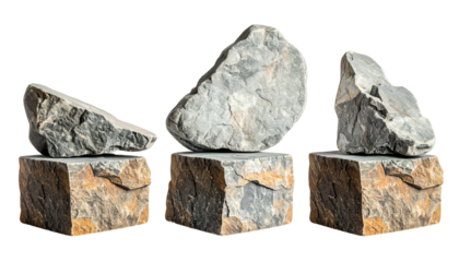 Three gray boulders rest atop rectangular stone pedestals, isolated against black