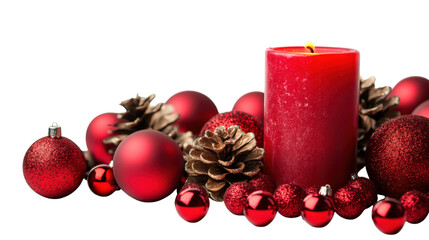 A red candle sits on a table with red ornaments and pine cones