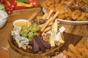 antipasti platter or charcuterie board, featuring a variety of cold and fried appetizers.  Cured meats and cheeses: Sliced meats, various  blue cheese and brie and breadsticks.