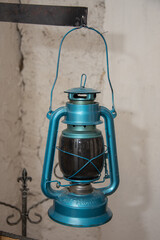  a blue metal kerosene or oil lantern, also known as a hurricane lamp. 
It is a vintage-style lantern designed to provide light using kerosene, lamp oil, paraffin, or citronella as fue