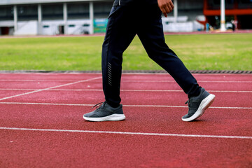 Fototapeta premium Person walking on a running track with athletic shoes and sportswear