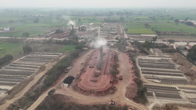 Drone footage of an old-style brick kiln in Okara, Pakistan. Aerial drone shot of a brick kiln factory where they are baking clay into bricks used for construction