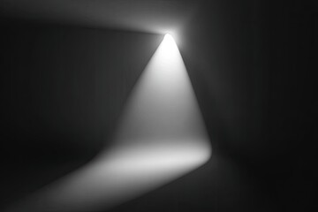 A white spotlight shines vertically in a dark space, radiating light downwards