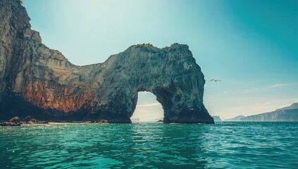 Basalt cliff with surface cave overlooking the ocean on bright day, geological stability