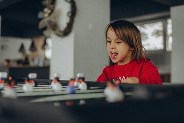 Happy Child Playing Foosball at Home Indoors