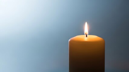 Single lit candle against blue background