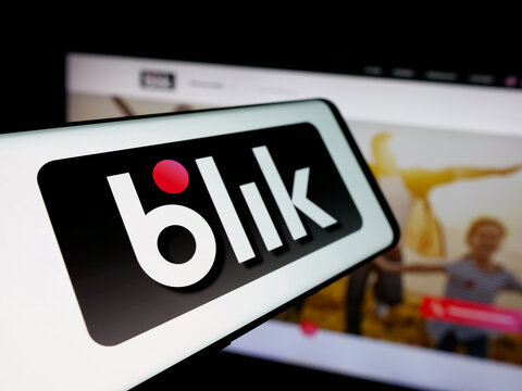 Stuttgart, Germany - 12-16-2025: Smartphone with logo of Polish mobile payment company Blik on screen in front of website. Focus on center-left of phone display.