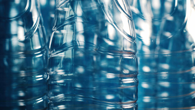 Empty plastic water bottles close-up as blue tinted abstract texture