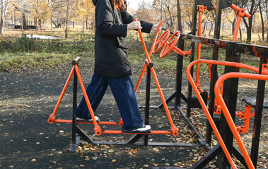Person using outdoor exercise equipment in a city park on a clear day