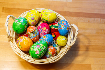 Basket with Easter eggs on wooden table