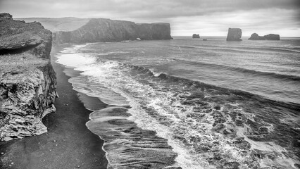 Stunning black sand beach with basalt rocks at Reynisfjara Iceland on cloudy summer day