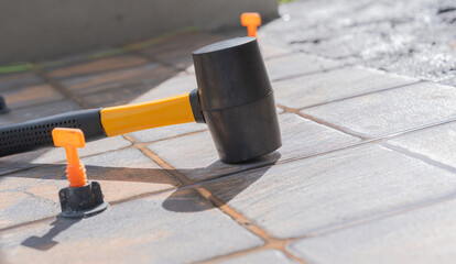 Mallet Hammer tiler tool isolated on tile floor construction house site Background, rubber hammer knock on ceramic tile cement glue flooring bathroom