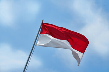 Indonesian flag, called the red and white flag, is flutters naturally in the blue sky.