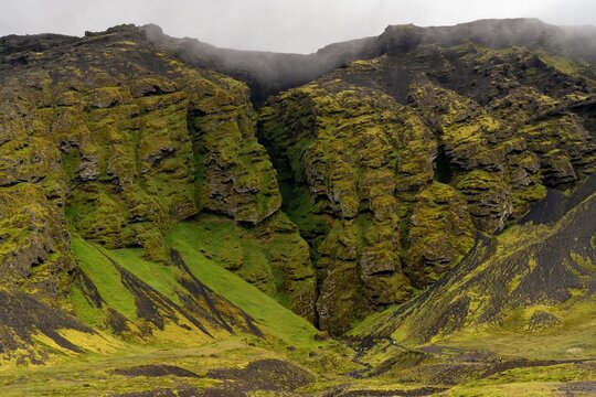 frontal view of the highland cliffs and the mythical Raudfelsgja gorge on a foggy and overcast day