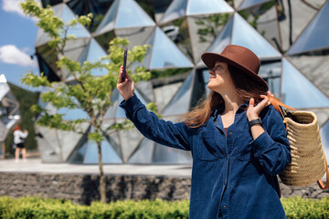 Woman takes selfie near modern building