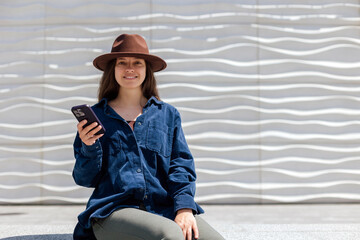 Young woman sitting with phone in a modern space