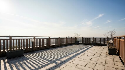 A serene rooftop patio with a wooden railing and potted plants overlooking a scenic view under a clear blue sky.