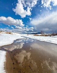 A puddle filled with melted snow water. Generative AI