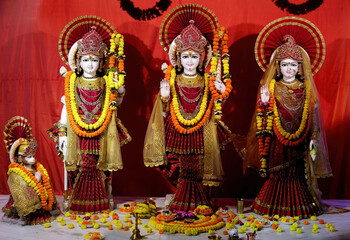 Close-up of Hindu deities Bhagwan Rama, Sita, and Lakshmana idols in a temple with routine decoration in Bodhgaya.