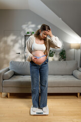 Pregnant woman stands on scale measuring tape around belly, looking concerned about weight gain during pregnancy