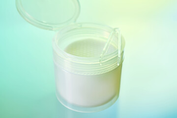 Skincare toner pads in plastic jar with tweezers