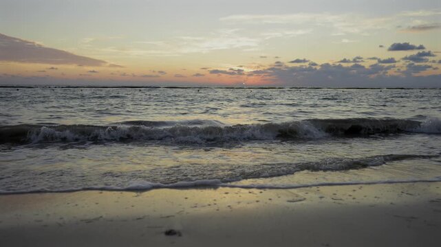 Waves crashing gently on a beach at the Riviera Maya in Mexico on a warm sunny morning