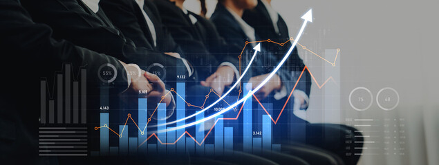 Business professionals participate in a conference setting focused on analyzing data visualizations and growth trends for strategic planning and decision-making. Scalp